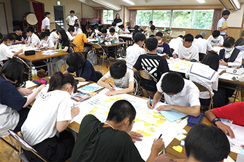 関東甲信越青少年交流会の様子の写真、机に向かい書き物をしている様子