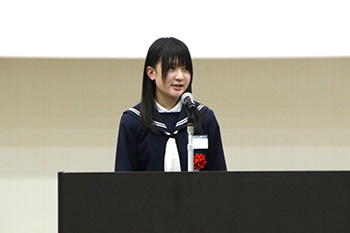 女生徒がスピーチ台からスピーチを行っている